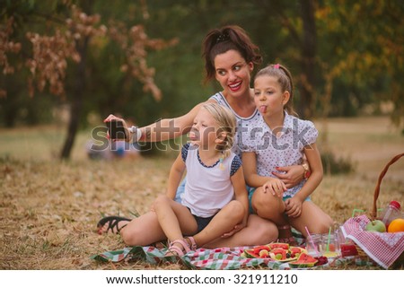Mother and two daughters taking selfie in nature