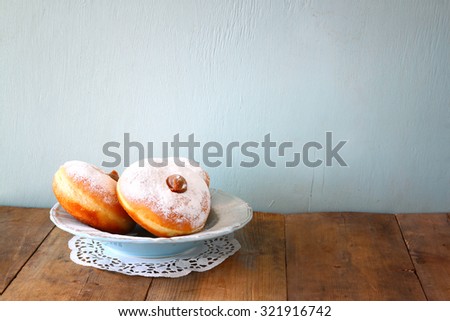 image of jewish holiday Hanukkah with donuts on wooden table 