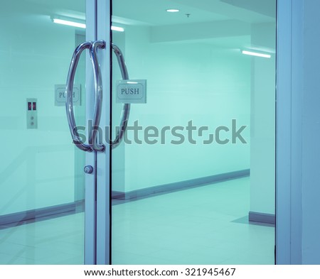 Glass door with chrome handles and push sign on door. Vintage filter effect image