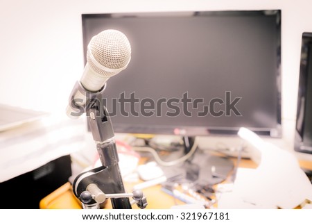 microphone on the background of blurred computer screen in office. soft focus .shallow depth of field. Vintage style and filtered process.