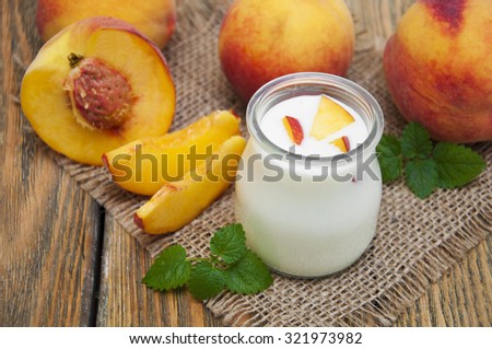 Homemade yogurt with fresh peaches on a wooden background