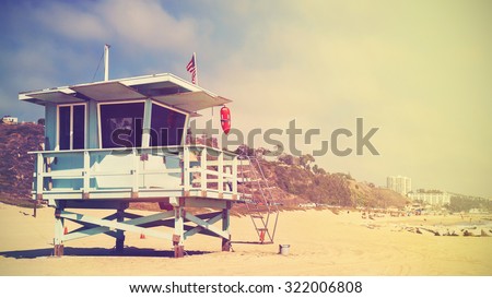 Retro stylized panoramic picture of a lifeguard tower in Santa Monica at sunset, California, USA.