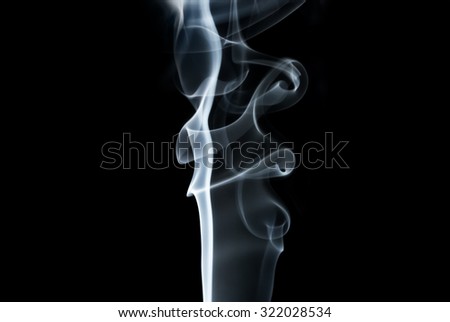 Photo of abstract light smoke swirls on black background. Studio shot.