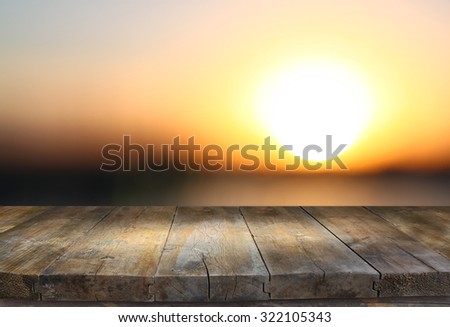 image of textured wood table in front of beach landscape at sunset time