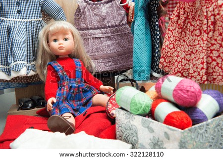 a blond toy doll with several dresses