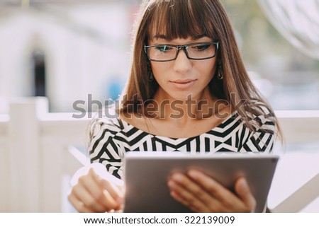 Pretty Girl using tablet phone in cafe