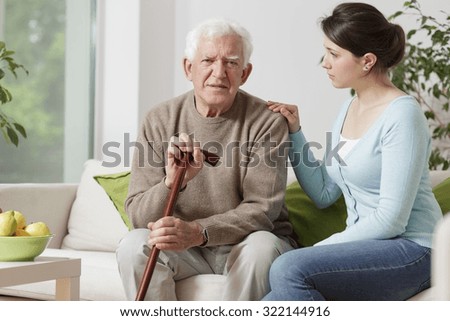 Image of elderly man with walking stick and his carer