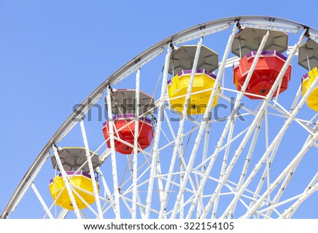 Close up picture of ferris wheel against blue sky in amusement park.