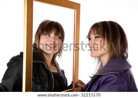 Twin girls holding a picture frame isolated against white