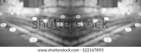 Symmetrical background with lights and people silhouettes. Intentionally blurred post production.