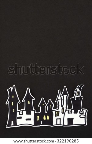 a vertical overhead view of a Halloween scene of some houses over a black background