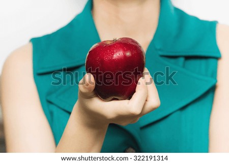 Red apple (shiny surface) in woman's hand, selective focus
