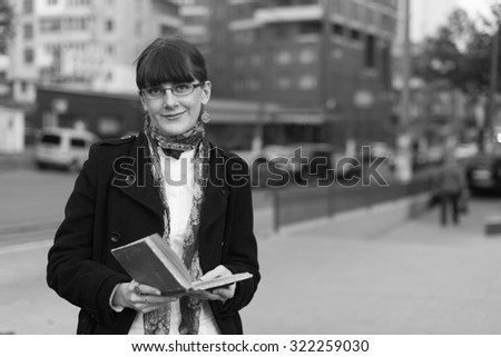 Black and White. Young woman reading a book in City urban