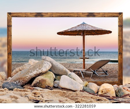 Rock on the beach with empty picture frame and blurred beach and sea