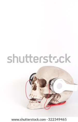 Human Skull listen to music by headset/headphone isolated on white Background