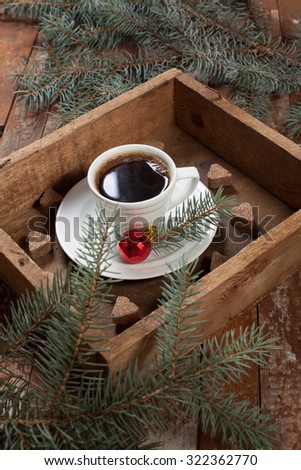 a cup of coffee in a vintage box with fir branches and Christmas decorations