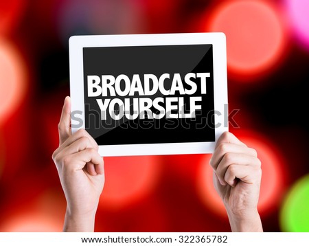 Tablet pc with text Broadcast Yourself with bokeh background