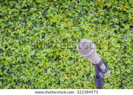 microphone on the background of blurred green leaves or bush. soft focus .shallow depth of field