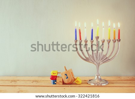 low key image of jewish holiday Hanukkah with menorah (traditional Candelabra) and wooden dreidels (spinning top) 