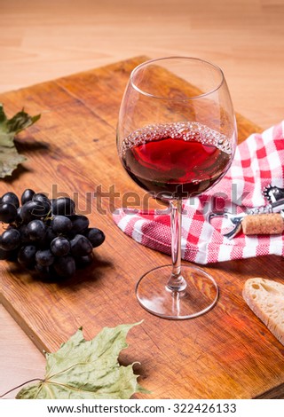 Pouring red wine glass against wooden background