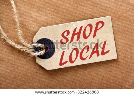The words Shop Local in red text on a brown paper price label or luggage tag with string and wrapping paper Royalty-Free Stock Photo #322426808