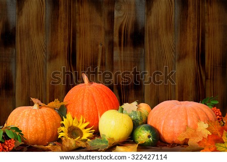 Autumn background with maple leaves and pumpkins on wooden table