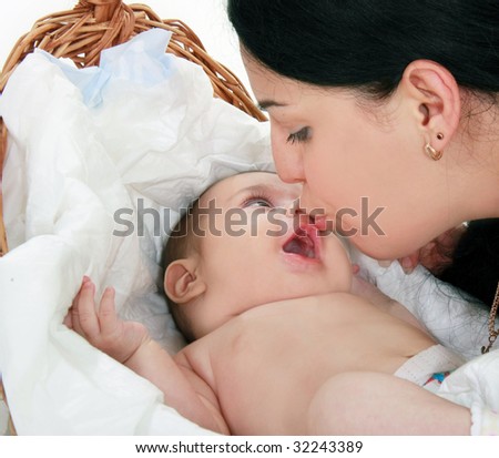 portrait of loving mother kissing her baby