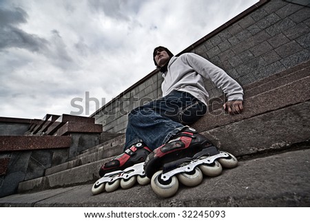 Wide angle portrait of a serious rollerskating man