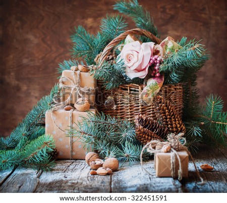 Still Life with Presents in Vintage Style. Boxes Decorated with Cord, Basket, Fir Tree, Toys, Walnuts, Almonds on Wooden Background