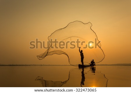 Fisherman throwing net at sunrise , Thailand Royalty-Free Stock Photo #322473065
