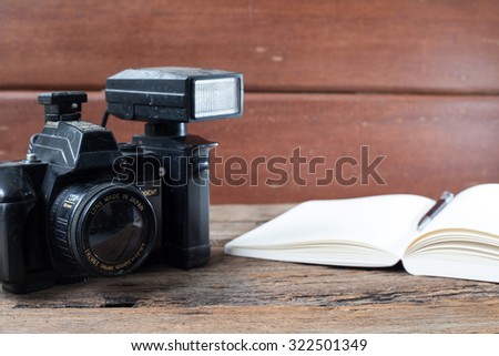 Vintage camera and book on wooden background