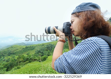 Asian woman photographer take a photo at viewpoint.