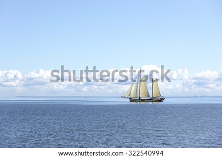 Sailing ship in the open blue sea.