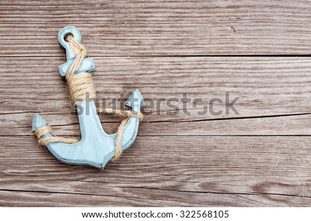 small blue anchor on a wooden background