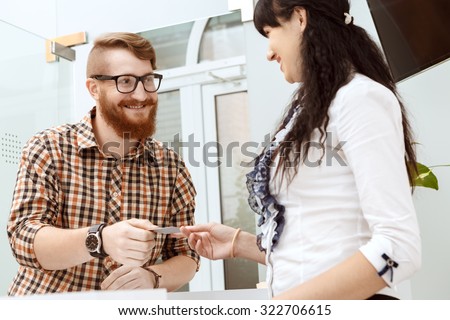 Office manager giving the customer a business card on reception