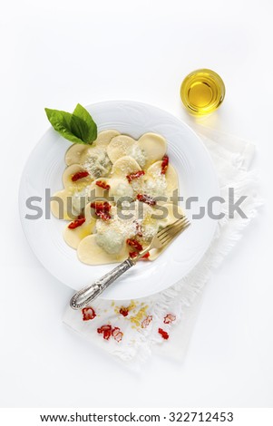 Heart shaped food. delicious ravioli. freshly homemade. cooked. in a white plate. with the basil leaves and olive oil.