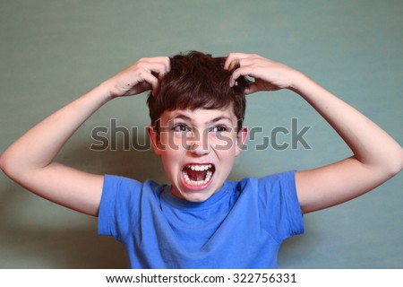 preteen handsome boy scratch his head isolated on blue