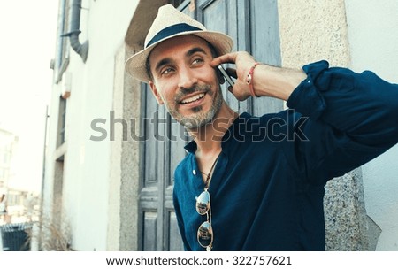 Handsome middle age man talking on the phone with smile at his face