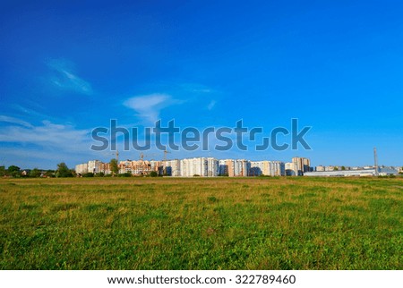 Cityscape on green grass and blue sky