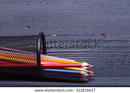 Palette set of colorful sharp pencils brown red yellow blue violet pink purple lilac grey black white and orange colors lying on wooden background copyspace, horizontal picture