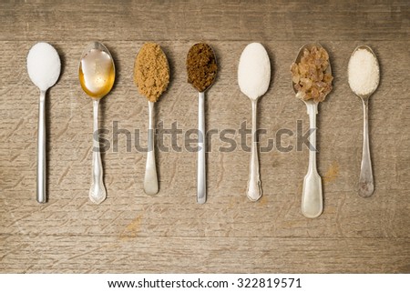 Seven teaspoons in a line with different types of sugar Royalty-Free Stock Photo #322819571