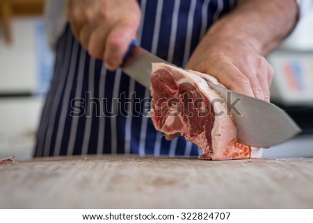 Friendly man preparing raw meat at the butchers Royalty-Free Stock Photo #322824707