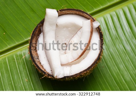 Coconut cut open, Coconut strips on a banana leaf, in Kerala India top view. Grated coconut  used in cooking, frying, seasoning, sambar, chutney, curry. coconut oil is used in soaps, cosmetics. 