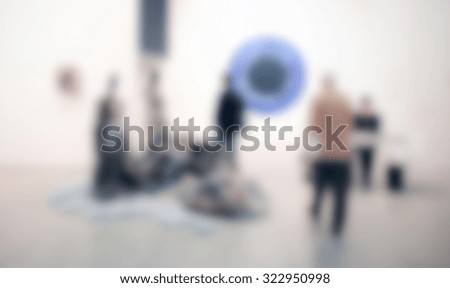 People visit exhibition art gallery, generic background. Intentionally blurred post production.