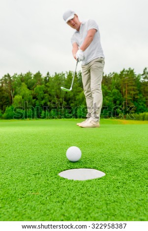 Vertical picture man playing golf on a green field
