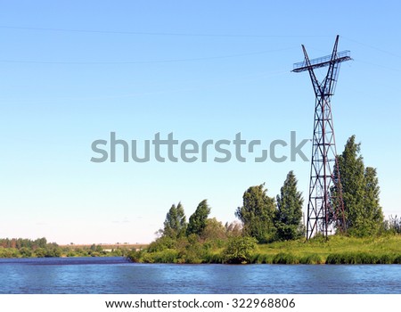 River coast line with green fresh grass and power transmission line at summer day
