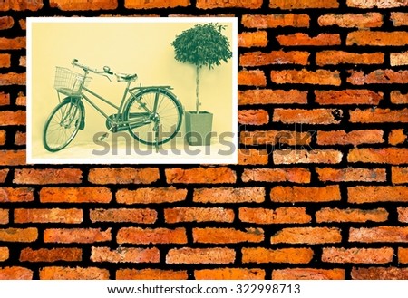 Vintage wallpaper of classic bicycle photo on old brick background.