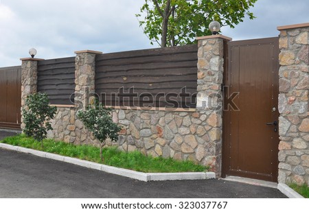 Stone and Metal Fence with Door of Modern Style Design Decorative Cracked Real Stone Wall Surface With Cement. 