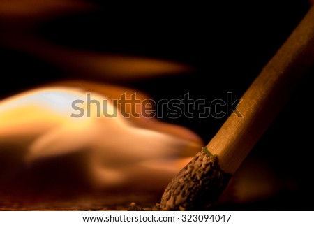 Macro shot of lit match shows flame coming from head of match