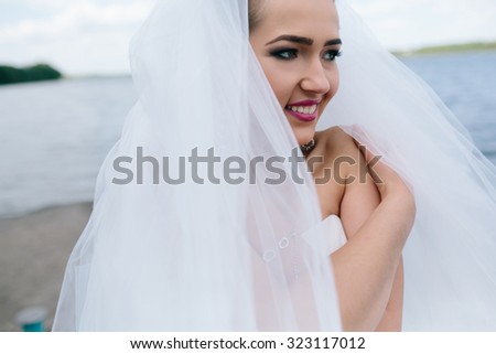 Portrait of pretty bride pictured in traditional white wedding dress. 